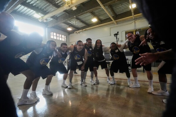 Twinning Project cohort 2 participants gather before performing basketball drills during the project's collaboration with the NBA's Golden State Warriors and the California Department of Corrections and Rehabilitation at Solano State Prison in Vacaville, Calif., Tuesday, Feb. 11, 2025. (AP Photo/Jeff Chiu)