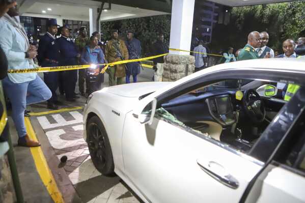 Crime scene unit investigators and Kenya Police detectives inspect a vehicle in which Kenyan MP Charles Ong'ondo Were was shot dead on Wednesday, April 30, 2025 night after his car stopped at a roundabout on a busy major road in the capital Nairobi. (AP Photo/Andrew Kasuku)