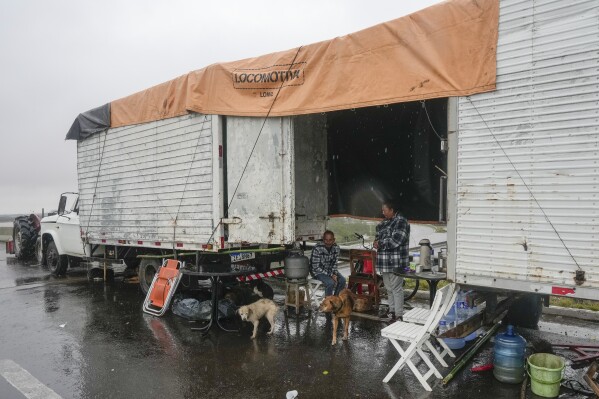 Menschen, die durch Überschwemmungen ihr Zuhause verloren haben, leben am Freitag, 10. Mai 2024, in einem LKW-Anhänger in Canoas, Bundesstaat Rio Grande do Sul, Brasilien. (AP Photo/Andre Penner)