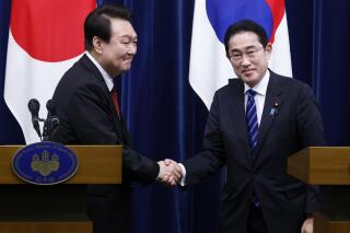FILE - South Korean President Yoon Suk Yeol, left, and Japanese Prime Minister Fumio Kishida, right, shake hands following a joint news conference at the prime minister's office in Tokyo, Japan, March 16, 2023. Prime Minister Kishida said he is arranging a May 7-8 trip to South Korea for talks with President Yoon in return to his March visit to Tokyo and give a boost to their impetus of deepening ties before the upcoming Group of Seven summit he hosts. (Kiyoshi Ota/Pool Photo via AP, File)