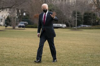 President Joe Biden waves as he arrives at the White House after visiting wounded troops and touring a COVID-19 vaccine center at Walter Reed National Military Medical Center, Friday, Jan. 29, 2021, in Washington. (AP Photo/Evan Vucci)