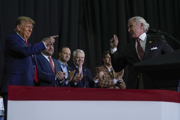 Republican presidential candidate former President Donald Trump, left, pointing to South Carolina Gov Henry McMaster, right, during a campaign event in Manchester, N.H., Saturday, Jan. 20, 2024. (AP Photo/Matt Rourke)