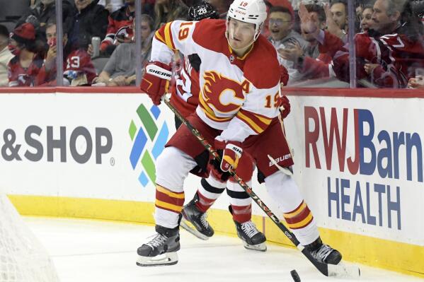Calgary Flames left wing Matthew Tkachuk (19) looks to pass the puck during the second period of an NHL hockey game against the New Jersey Devils Tuesday, Oct. 26, 2021, in Newark, N.J. (AP Photo/Bill Kostroun)