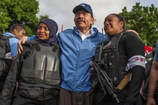 FILE - In this July 13, 2018 file photo, Nicaraguan police have their picture taken with President Daniel Ortega, after weeks of unrest in Masaya, Nicaragua. President Ortega is seeking a fourth consecutive term in November 2021, and he's pulling all the levers at his disposal to ensure his Sandinista National Liberation Front retains power. (AP Photo/Cristobal Venegas, File)