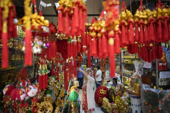 A buyer checks lucky charms for the coming Chinese New Year at Binondo district, said to be the oldest Chinatown in the world, in Manila, Philippines on Monday, Feb. 5, 2024. Crowds are flocking to Manila's Chinatown to usher in the Year of the Wood Dragon and experience lively traditional dances on lantern-lit streets with food, lucky charms and prayers for good fortune. (APPhoto/Aaron Favila)