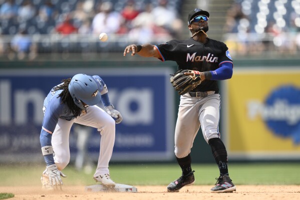 Washington Nationals' CJ Abrams, left, is forced out at second base as Miami Marlins shortstop Otto Lopez, right, throws to first but can't get Nationals' James Wood during the eighth inning of a baseball game, Saturday, June 14, 2025, in Washington. (AP Photo/Nick Wass)