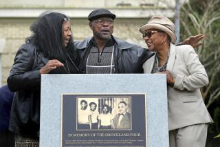 FILE - Relatives of the Groveland Four, from left, Vivian Shepherd, niece of Sam Shepherd, Gerald Threat, nephew of Walter Irvin; Carol Greenlee, daughter of Charles Greenlee, gather at the just-unveiled monument in front of the Old Lake County courthouse in Tavares, Fla., Feb. 21, 2020. Florida has formally cleared four Black men who were falsely accused of raping a white woman more than seven decades ago. At the request of the local prosecutor, a judge on Monday, Nov. 22, 2021 dismissed the charges and convictions against the Groveland Four: Ernest Thomas, Samuel Shepherd, Charles Greenlee and Walter Irvin. (Joe Burbank/Orlando Sentinel via AP)