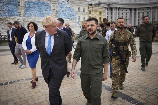 FILE - In this image provided by the Ukrainian Presidential Press Office, Ukrainian President Volodymyr Zelenskyy, centre, and Britain's Prime Minister Boris Johnson walk on the square where damaged Russian military vehicles are displayed in Kyiv, Ukraine, Friday, June 17, 2022. British Prime Minister Johnson has presented Ukrainian President Zelenskyy with the Sir Winston Churchill Leadership Award, drawing comparisons between the two leaders in times of crises. Zelenskyy accepted the award by video link Tuesday, July 26, 2022, during a ceremony at Johnson’s London office. (Ukrainian Presidential Press Office via AP, File)