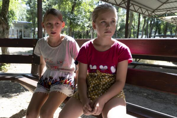 Ukrainian children Olesya Lyadchenko, left, and Yaroslava Rogachyova attend a camp in Zolotaya Kosa, the settlement on the Sea of Azov, Rostov region, southwestern Russia, Friday, July 8, 2022. An Associated Press investigation has found that Russia’s strategy to take Ukrainian orphans and bring them up as Russian is well underway. Yaroslava said she will miss the sea and Donetsk, but she has already met – only via video link by then her new family and likes them. (AP Photo)
