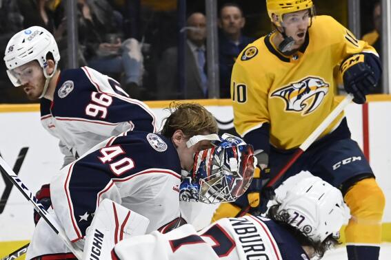 The mask of Columbus Blue Jackets goaltender Daniil Tarasov (40) comes off after he blocked a shot by the Nashville Predators during the second period of an NHL hockey game Tuesday, Jan. 17, 2023, in Nashville, Tenn. (AP Photo/Mark Zaleski)