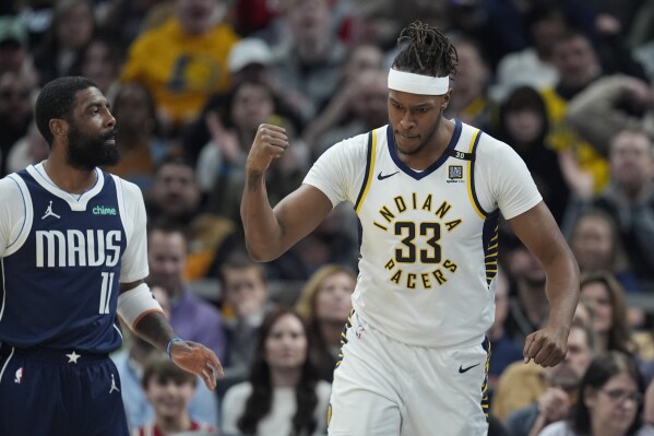 Indiana Pacers' Myles Turner (33) reacts in front of Dallas Mavericks' Kyrie Irving (11) after hitting a basket and getting fouled during the first half of an NBA basketball game, Sunday, Feb. 25, 2024, in Indianapolis. (AP Photo/Darron Cummings)