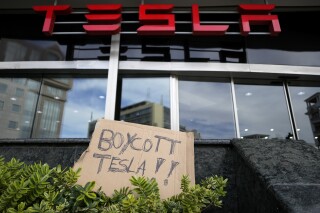 A banner is left outside a Tesla showroom during a demonstration, in Lisbon, Sunday, March 9, 2025. (AP Photo/Armando Franca)