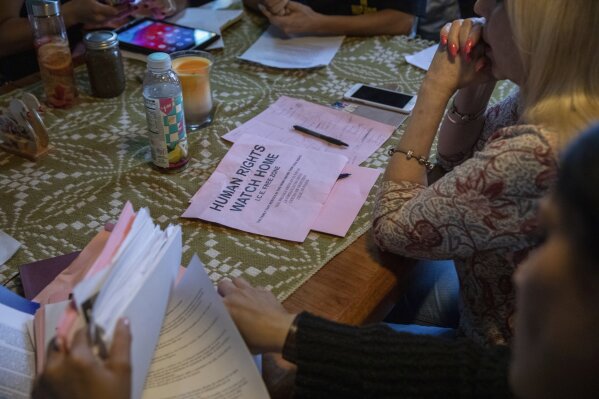 In this Wednesday, June 19, 2019 photo, a flyer that reads  "Human Rights Watch Home, ICE Free Zone " rests on a table during an emergency meeting plan of action on how to defend and protect undocumented communities of deportation at Lincoln Methodist Church in Chicago's Pilsen neighborhood. With renewed pledges on mass deportations, immigrant rights activists have fine-tuned and ramped up one of their most basic organizing tools: The know-your-rights training. (AP Photo/Amr Alfiky)