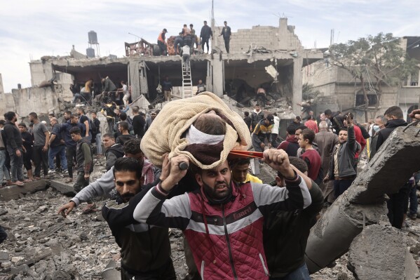 Palestinians evacuate an injured woman after an Israeli airstrike on the Khan Younis refugee camp in the southern Gaza Strip, Thursday, Dec. 7, 2023.  (AP Photo/Mohammed Dahman)