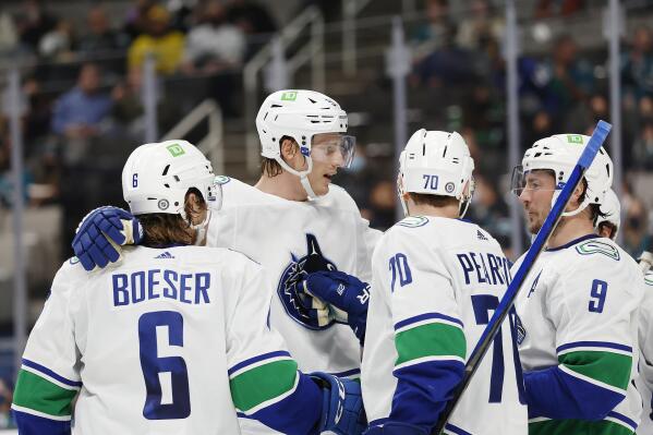 Vancouver Canucks right wing Brock Boeser (6) celebrates with defenseman Tyler Myers (57), center, left wing Tanner Pearson (70), center J.T. Miller (9) after scoring goal during the second period of an NHL hockey game against San Jose Sharks Thursday, Dec. 16, 2021, in San Jose, Calif. (AP Photo/Josie Lepe)