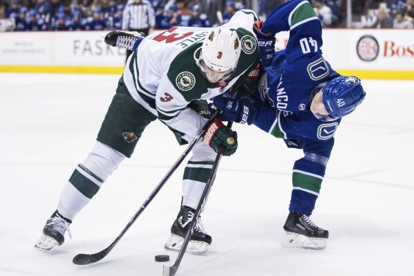 
              Minnesota Wild's Charlie Coyle, left, and Vancouver Canucks' Elias Pettersson, of Sweden, vie for the puck during the first period of an NHL hockey game in Vancouver, British Columbia, Tuesday Dec. 4, 2018. (Darryl Dyck/The Canadian Press via AP)
            