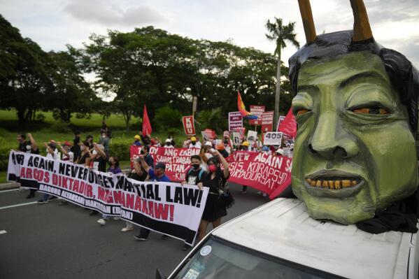 Human rights groups pass by an effigy of Philippine President Ferdinand Marcos Jr. as they mark the 50th anniversary of martial law at the University of the Philippines in Metro Manila, Philippines, Wednesday, Sept. 21, 2022. Survivors of torture and other atrocities under Philippine dictator Ferdinand Marcos on Wednesday marked his martial law declaration 50 years ago by pressing their demand for justice and apology from his son, now the country's president in a stunning reversal of fortunes for the once reviled family. (AP Photo/Aaron Favila)