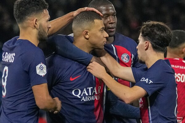 PSG's Kylian Mbappe celebrates with teammates after scoring his side's second goal during the French League One soccer match between Paris Saint-Germain and Monaco, at the Parc des Princes stadium in Paris, France, Friday, Nov. 24, 2023. (AP Photo/Michel Euler)