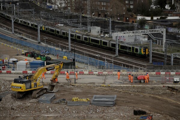 FILE - A train passes the construction site of the High Speed 2 (HS2) rail line at Euston station in London, Tuesday, Feb. 11, 2020. The British government confirmed Sunday, Sept. 24, 2023 it may scrap a big chunk of an overdue, over-budget high-speed rail line once touted as a key way to attract jobs and investment to northern England. (AP Photo/Matt Dunham, File)