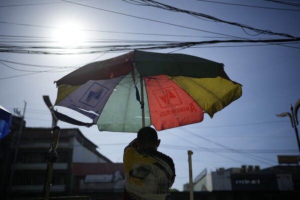A vendor prepares his umbrella as hot days continue in Manila, Philippines on Monday, April 29, 2024. Millions of students in all public schools across the Philippines were ordered to stay home Monday after authorities cancelled in-person classes for two days as an emergency step due to the scorching heat and a public transport strike. (AP Photo/Aaron Favila)
