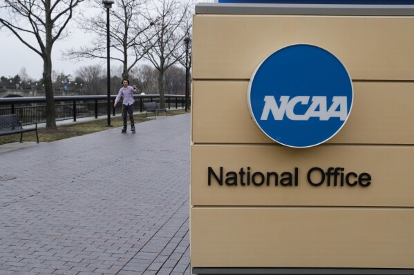 FILE - NCAA signage outside the headquarters in Indianapolis, Thursday, March 12, 2020. Forced into yet another courtroom to defend its amateur model of athletics, the NCAA argued that shelving its rules against name, image and likeness compensation being offered to recruits would make an already difficult situation across the country even more chaotic. (AP Photo/Michael Conroy, File)