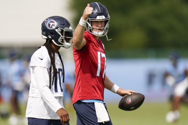 Tennessee Titans quarterback Ryan Tannehill, right, gives a thumbs up as he walks with wide receiver DeAndre Hopkins during an NFL football training camp practice Wednesday, July 26, 2023, in Nashville, Tenn. (AP Photo/George Walker IV)