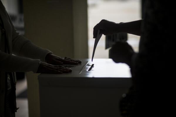 A Gibraltarian casts a vote at a polling station during a referendum in Gibraltar, Thursday, June, 24, 2021. Gibraltar is holding a referendum on whether to introduce exceptions to the British territory's ban on abortion. Abortion is illegal in Gibraltar, unless it is needed to save the mother's life. Abortion is legally classified as "child destruction" and is punishable by up to life in prison. (AP Photo/Javier Fergo)