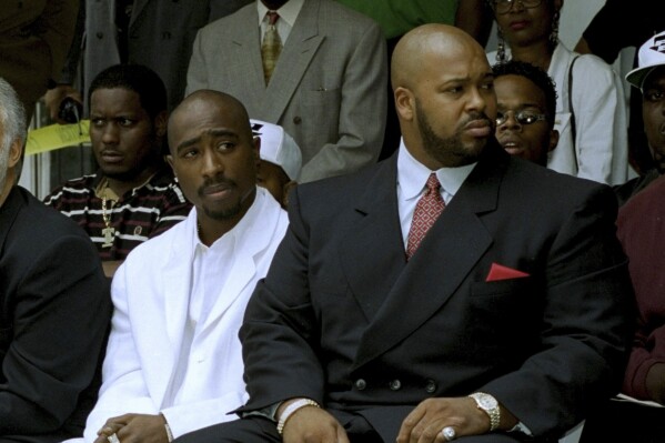 FILE - Rapper Tupac Shakur, left, and Death Row Records Chairman Marion "Suge" Knight, attend a voter registration event in South Central Los Angeles, August 15, 1996. Shakur's shooting in a New York recording studio in the mid-1990s sparked hip-hop's biggest rivalry and led to the shocking deaths of two of the genre's greatest stars. Shakur and Notorious B.I.G. were gunned down in drive-by shootings only six months apart. Nearly three decades later, the recent arrest of longtime suspect Duane “Keffe D” Davis has ignited another wave of intrigue in their unsolved murders. (AP Photo/Frank Wiese, File)