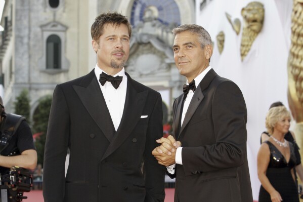 FILE - Actors Brad Pitt, left, and George Clooney appear at the screening of the movie "Burn After Reading," opening the 65th edition of the Venice Film Festival in Venice, Italy on Aug. 27, 2008. (AP Photo/Joel Ryan, File)