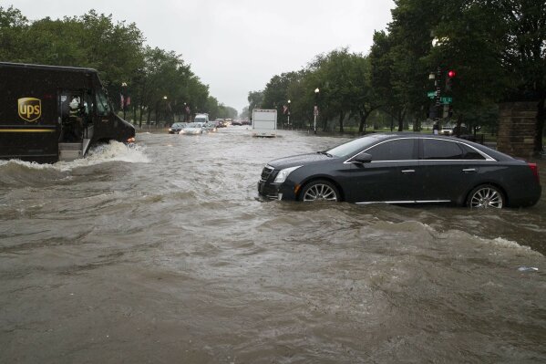 Heavy rainfall flooded the intersection of 15th Street and Constitution Ave., NW stalling cars in the street, Monday, July 8, 2019, in Washington. (AP Photo/Alex Brandon)