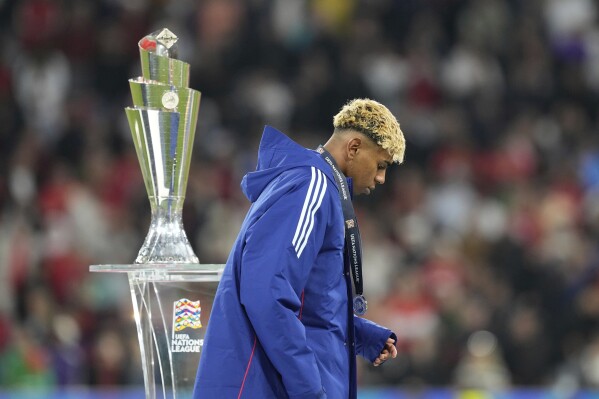 Spain's Lamine Yamal walks past the trophy after received his second place medal during the Nations League final soccer match between Portugal and Spain at the Allianz Arena in Munich, Germany, Monday, June 9, 2025. (AP Photo/Martin Meissner)