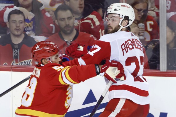Detroit Red Wings' Michael Rasmussen. right, runs into Calgary Flames' Oliver Kylington during the second period of an NHL hockey game in Calgary, Alberta, Saturday, Feb. 17, 2024. (Larry MacDougal/The Canadian Press via 番茄直播)