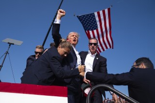 Republican presidential candidate former President Donald Trump is surrounded by U.S. Secret Service agents at a campaign rally, Saturday, July 13, 2024, in Butler, Pa. Social media users are sharing an edited version of this photo that makes it appear the agents were smiling. (AP Photo/Evan Vucci)