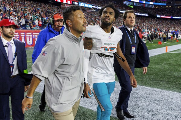 Miami Dolphins wide receiver Jaylen Waddle (17) walk out the field with the medical team after he got injured in a play against the New England Patriots during fourth quarter of an NFL football game at Gillette Stadium on Sunday, Sept. 17, 2023 in Foxborough, Ma. (David Santiago/Miami Herald via AP)