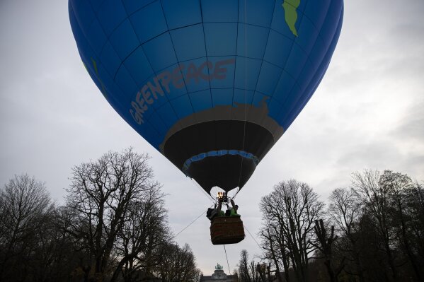 Environmental activists launch a hot air balloon during a demonstration outside of an EU summit in Brussels, Thursday, Dec. 10, 2020. European Union leaders meet for a year-end summit that will address anything from climate, sanctions against Turkey to budget and virus recovery plans. Brexit will be discussed on the sidelines. (AP Photo/Francisco Seco)