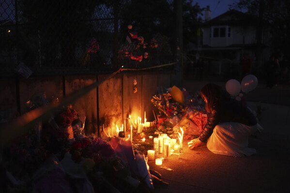 A woman pays her respects at a memorial for victims after a vehicle drove into a crowd during a Filipino heritage festival in Vancouver, British Columbia, Sunday, April 27, 2025. (AP Photo/Lindsey Wasson)