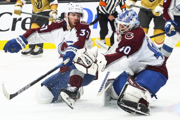 Colorado Avalanche goaltender Alexandar Georgiev (40) makes a save against the Vegas Golden Knights, next to Avalanche left wing J.T. Compher (37) during the second period of an NHL hockey game Saturday, Oct. 22, 2022, in Las Vegas. (AP Photo/Chase Stevens)