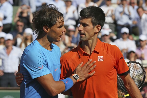 FILE - Serbia's Novak Djokovic hugs Spain's Rafael Nadal, left, after winning the quarterfinal match of the French Open tennis tournament in three sets, 7-5, 6-3, 6-1, at Roland Garros stadium, in Paris, France, Wednesday, June 3, 2015. There have been 59 installments of Nadal vs. Djokovic, more than between any two other men in the Open era of tennis, which dates to 1968. Djokovic leads 30-29 overall. (AP Photo/David Vincent, File)