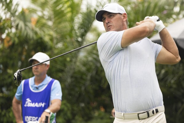Captain Brooks Koepka, right, of Smash GC, hits on the fifth tee during the second round of LIV Golf Singapore at Sentosa Golf Club, Saturday, May 4, 2024, in Sentosa, Singapore. (LIV Golf via AP)