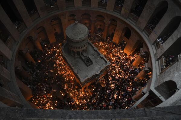 Christians pilgrims hold candles during the Holy Fire ceremony, a day before Easter, at the Church of the Holy Sepulcher, where many Christians believe Jesus was crucified, buried and resurrected, in Jerusalem's Old City, Saturday, April 15, 2023. (AP Photo/Tsafrir Abayov)