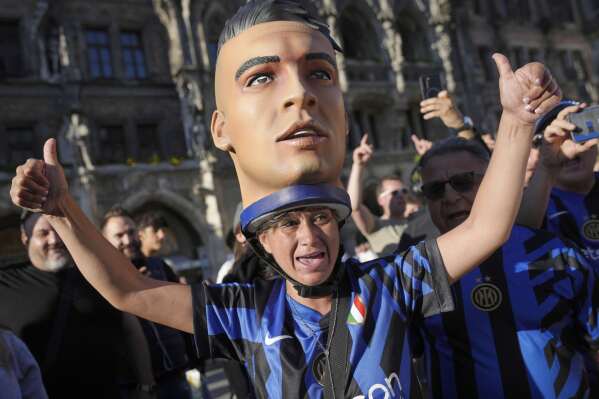 An Inter fan, wearing an effigy of Lautaro Martinez on her head reacts ahead of the Champions League final soccer match between Paris Saint-Germain and Inter Milan in Munich, Germany, Friday, May 30, 2025. (AP Photo/Markus Schreiber)