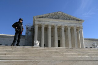 A U.S. Supreme Court police officer stands in fron of the U.S. Supreme Court Wednesday, Feb. 7, 2024, in Washington. The Supreme Court hears arguments on Feb. 8 over whether former President Donald Trump can be kept off the ballot because of his efforts to overturn the 2020 election results, culminating in the Jan. 6, 2021 attack on the Capitol. (AP Photo/Jose Luis Magana)