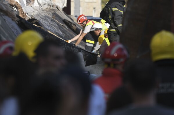 Rescue workers search for victims in the aftermath of an outdoor roof collapse at a train station in Novi Sad, Serbia, Friday, Nov. 1, 2024. (AP Photo)