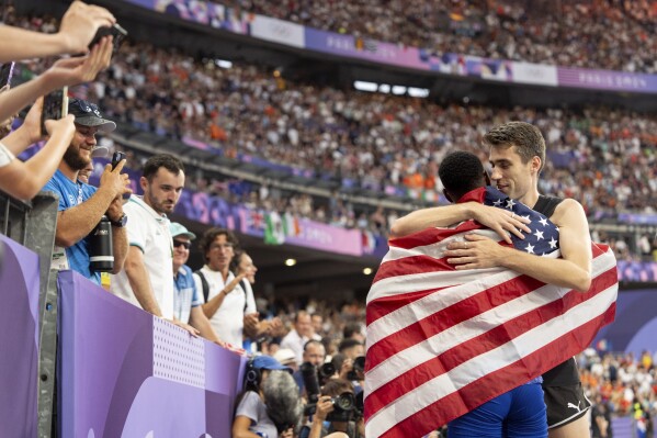 Hamish Kerr, of New Zealand, right, hugs Shelby McEwen, of the United States, after Kerr took gold and McEwen silver in the men's high jump at the 2024 Summer Olympics, Aug. 10, 2024, in Saint-Denis, France. (AP Photo/David Goldman, File)