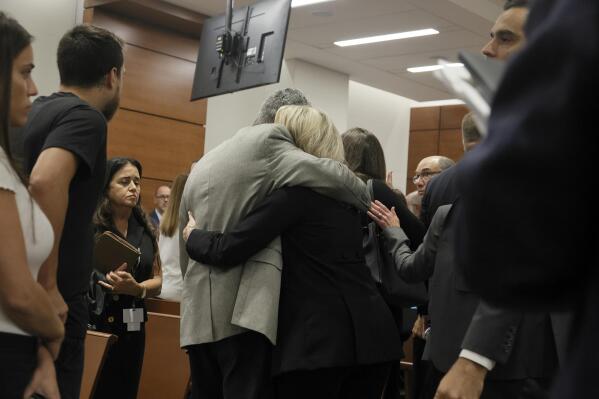 Tom and Gena Hoyer exit the courtroom as Gena could be heard sobbing following the verdict in the trial of Marjory Stoneman Douglas High School shooter Nikolas Cruz at the Broward County Courthouse in Fort Lauderdale, Fla., on Thursday, Oct. 13, 2022. The Hoyer's son, Luke, was killed in the 2018 shootings.  A jury spared Cruz from the death penalty Thursday for killing 17 people at a Parkland high school in 2018, sending him to prison for the remainder of his life. (Amy Beth Bennett/South Florida Sun-Sentinel via AP, Pool)