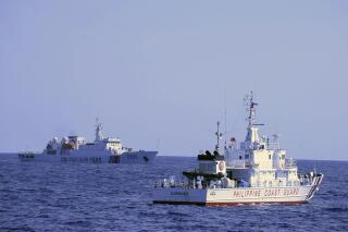 In this photo provided by the Philippine Coast Guard, a Chinese Coast Guard ship sails near a Philippine Coast Guard vessel during its patrol at Bajo de Masinloc, 124 nautical miles west of Zambales province, northwestern Philippines on March 2, 2022. A Chinese coast guard ship last month maneuvered for days near a research vessel deployed by Philippine and Taiwanese scientists to undertake a crucial survey of undersea fault lines west of the northern Philippines, sparking concerns among the scientists on board, officials said Thursday, April 7, 2022. (Philippine Coast Guard via AP)