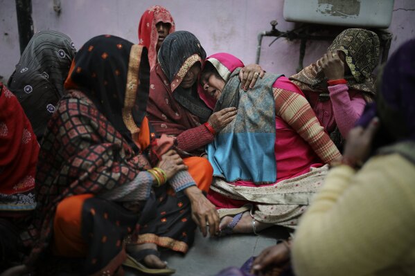 Family members of Rahul Solanki, who was killed during clashes between Hindu mobs and Muslims protesting a contentious new citizenship law, weep outside a mortuary in New Delhi, India, Wednesday, Feb. 26, 2020. At least 20 people were killed in three days of clashes in New Delhi, with the death toll expected to rise as hospitals were overflowed with dozens of injured people, authorities said Wednesday. The clashes between Hindu mobs and Muslims protesting a contentious new citizenship law that fast-tracks naturalization for foreign-born religious minorities of all major faiths in South Asia except Islam escalated Tuesday. (AP Photo/Altaf Qadri)