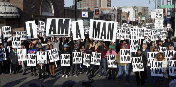 People hold signs resembling the signs carried by striking sanitation workers in 1968 as they join in events commemorating the 50th anniversary of the assassination of the Rev. Martin Luther King Jr. on Wednesday, April 4, 2018, in Memphis, Tenn. King was assassinated April 4, 1968, while in Memphis supporting striking sanitation workers. (AP Photo/Mark Humphrey, File)