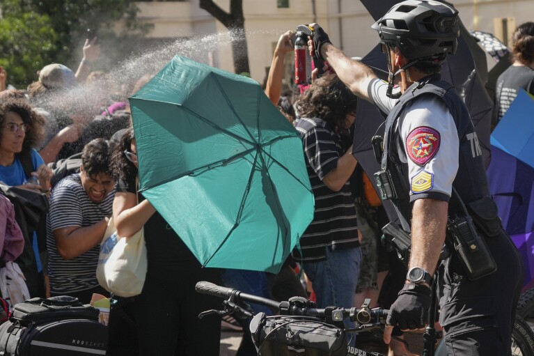 جندي بالولاية يرش الفلفل على المتظاهرين في مظاهرة مؤيدة للفلسطينيين في جامعة تكساس في أوستن، تكساس، الاثنين 29 أبريل 2024.  (جاي جانر / أوستن أمريكان ستيتسمان عبر AP)