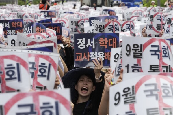 A teacher shouts slogans during a rally to demand the better protection of their rights near the National Assembly in Seoul, South Korea, Saturday, Sept. 16, 2023. Following the suicide of an elementary school teacher in July, teachers across South Korea have been pushing for improved systems to protect teachers from widespread malicious complaints from parents. The sign reads "Grant teachers immunity from child emotional abuse claims" (AP Photo/Ahn Young-joon)